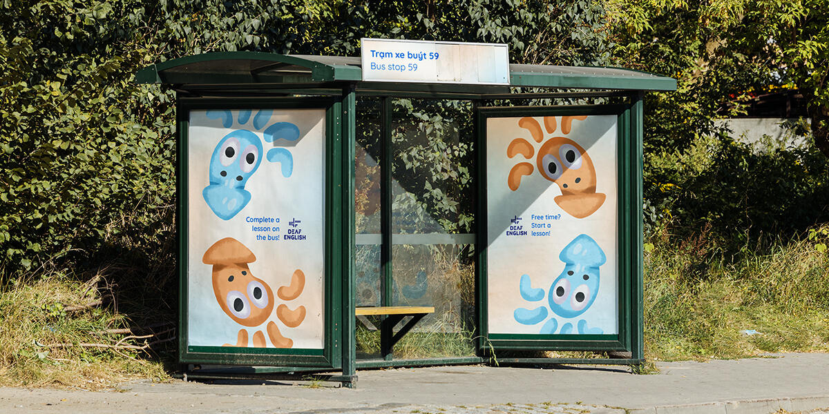 Cover Image for "Deaf English" Cover image for the project "Deaf English". The image depicts a bus top with two large posters advertising for the English-learning application. The posters features the two main squid characters.